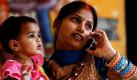 Multitasking: Eine indische Frau hält mit der einen Hand ihr Kind, während sie mit der anderen ein Telefonat führt. In Indien boomt der Markt für Mobiltelefone.  Foto: ap