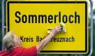 Es gibt sie wirklich: Die Gemeinde Sommerloch, die in der Nähe von Rüdesheim (Rheinland-Pfalz) liegt und rund 430 Einwohner groß ist. Jedes Jahr muss ihr Ortseingangsschild für die Illustration herhalten, wenn sich Politiker aus der hinteren Reihe in der Saure-Gurken-Zeit mit absurden Vorschlägen in die Öffentlichkeit wagen. Foto: dpa