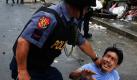 Ein Philippine wird am Rande von Barackenabrissen in Quezon City im Osten Manilas von einem Polizisten festgehalten. Illegale Siedler versperrten zunächst den Eingang zu einem Gebiet von Shanties, das von mehr als 150 Familien besetzt wird. Die Polizei unterstützte die Arbeit der Gruppe von Abreißern. Foto: dpa