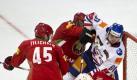 Weißrussische (rot) und slowakische Eishockeyspieler stochern bei einem Turnier in Arosa vor dem Tor Weißrusslands nach dem Puck. Foto: Ennio Leanza. Foto: dpa