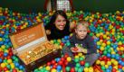 Die Fernsehpädagogin Katharina Saalfrank ('Die Super-Nanny') sitzt am Montag (14.04.2008) beim Kindernotdienst in Berlin mit dem Mitarbeiterkind Ben (3) und einem mit symbolischen Goldtalern gefüllten Koffern in einer Spielbox voller bunter Plastikbälle. Der mit Talern gefüllte Koffer steht für eine Spende von 24.551 Euro, die dem Kindernotdienst Berlin als Erlös aus dem Vattenfall-Halbmarathon zugute kommt. Foto: Soeren Stache dpa/lbn +++(c) dpa - Bildfunk+++ Foto: dpa
