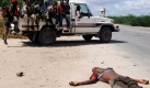 Somalische Regierungsvertreter fahren an einem Leichnam eines Rebellen in Mogadischu vorbei. Foto: ap