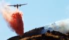 Ein Löschflugzeug wirft über den Vasque Rocks in Kalifornien Brandschutzmittel ab. Die Gegend nahe der Stadt Aqua Dulce brennt seit Tagen. Die Feuerwehr hat die Flammen noch immer nicht vollständig unter Kontrolle. Berühmt wurde die Gegend mit den monolithischen Felsen als Kulisse vieler Hollywoodfilme und Serien. Auch die Kultserie Star Trek wurde hier gedreht. Foto: dapd