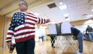 Wearing a sweater with the colors of the U.S. flag, election official Phillip Schlafer guides voters to the polling booths Tuesday, Nov. 2, 2010, at the Grand Chute Town Hall in Grand Chute, Wis. (AP Photo/Post-Crescent, Dan Powers) Foto: dapd