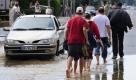 Passanten laufen am in Görlitz auf der vom Hochwasser der Neiße überfluteten Bundesstrasse 99, die in Richtung Zittau führt. Auf der Altstadt-Brücke herrscht am frühen Morgen dichtes Gedränge. Die Görlitzer halten die Folgen der Flut in Bildern fest. Überall Kopfschütteln. Das ist doch nicht möglich, sagt Ursula Pickroth fassungslos. Die reißenden braunen Wassermassen haben Straßen und Wege überspült. Das Dach eines Autos ragt aus dem Wasser. Dort drüben war ein Restaurant, alles unter Wasser, sagt die Rentnerin. Foto: ddp