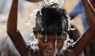 Ein Junge gießt sich in Allahabad in Indien einen Eimer Wasser über den Kopf. Der Norden Indiens leidet seit Wochen unter ungewöhnlicher Hitze. Die Bewohner erwarten daher sehnlichst die Regenzeit. Foto: ap