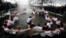 Bulgarische Männer singen und tanzen um einen Jungen, der ein Heiliges Kreuz in der Hand hält. Der feierliche Tanz zum Dreikönigsfest wird traditionell im Fluss Tundzha abgehalten. Der Legende nach soll der Tanz im Wasser die Gesundheit erhalten. Foto: ap