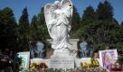 Bilder und Blumen stehen in Hamburg auf dem Friedhof Ohlsdorf am Grab der verstorbenen Erotikdarstellerin Carolin Wosnitza neben dem Grabstein in Form eines Engels. Die unter dem Künstlernamen Sexy Cora bekannte junge Frau starb am 20. Januar 2011 nach Komplikationen nach einer Brustoperation. Foto: dapd