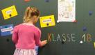 Eine Schulanfängerin holt ihr Namensschild von der Tafel. Foto: ap