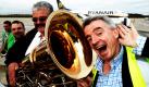 Michael O'Leary, Chef der irischen Low-Cost-Airline Ryanair (rechts), lauschte am Rande der Begrüßung des 30-millionsten Passagiers der Ryanair am Flughafen Frankfurt-Hahn an einer Tuba. Ryanair bietet seit elf Jahren Flüge von dem ehemaligen US-Militärflughafen im Hunsrück an. Foto: dpa