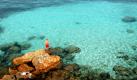 Ein Urlauber steht auf der Mittelmeerinsel Formentera in der Nähe des Strandes Cala Saona bei San Francisco auf einem Felsen. Ein Strand mit Blick auf das türkisfarbene Meer, ein tiefblauer Himmel, eine zartgrüne Frühlingswiese: Farben sind Teil des Lebens - und ein Mangel an Farbe kann krank machen, wie eine Untersuchung ergab, bei der sich die Teilnehmer längere Zeit in farblosen Räumen aufhielten. Foto: ddp