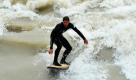 Ein Mann surft in München auf der hochwasserführenden Isar.  Foto: dpa