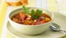 Scharfe Sauerkrautsuppe
Zutaten: 1 Zwiebel, 1 Möhre, 600 g Kartoffeln, 1 rote Chilischote, 1 Bund Petersilie, 1 Dose weiße Bohnen (250 g), 150 g Cabanossi, 50 g Margarine (z.B. Rama), 1 Dose Sauerkraut (800 g), 1 Dose Tomaten (800 g), 1,25 l (1250 ml) Brühe
Zubereitung: Zwiebel, Möhre und Kartoffeln schälen, Zwiebel fein würfeln, Möhre und Kartoffeln in zirka einen Zentimeter große Stücke schneiden. Die Chilischote waschen, entkernen und fein würfeln. Petersilie waschen, trockenschütteln und fein hacken sowie die Bohnen abtropfen lassen, danach die Cabanossi in Scheiben schneiden. Magarine in einem Topf erhitzen, Zwiebel, Möhre, Kartoffeln und Chili darin zirka fünf Minuten dünsten. Sauerkraut, Dosentomaten und Brühe dazugeben, aufkochen und zirka 20 Minuten köcheln lassen. Bohnen und Cabanossi dazugeben und erhitzen. Mit Petersilie servieren. Foto: Unilever