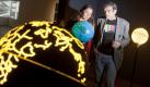 Die beiden Kuratoren und Künstler Antje Ehmann (l) und Harun Farocki (r) stehen im Museum Mathildenhöhe in Darmstadt bei der Vorbesichtigung der Ausstellung Serious Games zwischen einer Installation von Weltkugeln, die das Kunstwerk World Processor von Ingo Günther bilden. Die Ausstellung findet vom 27.03. bis zum 24.07.2011 statt. Foto: dpa