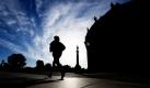 Eine Joggerin läuft am Morgen über die nördliche Monbijoubrücke in Berlin und zeichnet sich dabei als dunkle Silhouette neben dem Bodemuseum ab. Foto: dpa