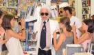 Nicht am Strand, dafür in einem Strandkiosk erwischen die Fans Modezar Karl Lagerfeld (Mitte) plus Bodyguard Sebastien Jondeau (rechts) in St. Tropez. Dem Gesichtsausdruck von Karl dem Großen ist nicht zu entnehmen, ob er entsetzt ist oder den jungen Fans gerade Auskunft erteilt. Foto: dpa