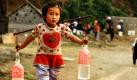 Ein Mädchen trägt im Süden Chinas zwei Flaschen Trinkwasser, welches sie von einer Quelle geholt hat. Die schlimmste Dürre zeit Jahrzehnten belastet die südlichen Regionen des Landes, sodass in Erwägung gezogen wird, künstlich Regen hervorzurufen. Foto: ap
