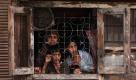 Eine Familie aus in Srinagar (Indien) schaut nach einem Zusammenstoß von Regierungstruppen und Rebellen verängstigt aus einem Fenster. Die Krisenregion Kashmir wurde seit Juni von zahlreichen Kämpfen heimgesucht, bei denen mehr als 100 Menschen umgekommen sind. Foto: ap