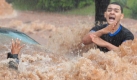 Gefangen in den Fluten: Wassermassen haben eine hilflose Frau erfasst, ein Mann schreit verzweifelt um Hilfe. Nach starkem Regen sind vielerorts in Brasilien die Flüsse über die Ufer getreten. Foto: dpa