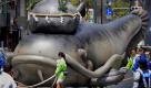 Japaner ziehen während des Kanda Myojin Festivals einen aufblasbaren Wels mit einem Stein auf dem Kopf durch Tokio. Der Fisch gilt als Symbol für Erdbeben, der Stein soll die Kraft von Erschütterungen in sich tragen. Foto: ap