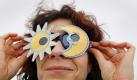 ILLUSTRATION - Eine Frau schaut am Dienstag (04.01.2011) in der Nähe von Schwerin durch eine selbst gebaute Sonnenfinsternisbrille (inszeniertes Foto). Die partielle Sonnenfinsternis kann wegen starker Bewölkung in Norddeutschland nicht beobachtet werden. Bei dem seltenen Naturschauspiel schiebt sich der Neumond am Morgenhimmel vor die Sonne und macht sie zur Sichel. Foto: Jens Büttner dpa/lmv +++(c) dpa - Bildfunk+++ Foto: dpa