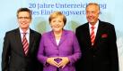 Bundeskanzlerin Angela Merkel steht zu Beginn einer Festveranstaltung zum 20. Jahrestag der Unterzeichnung des Einigungsvertrages zwischen Bundesinnenminister Thomas de Maizière und Kulturstaatsminister Bernd Neumann (rechts). Foto: dpa