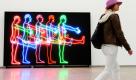Eine Frau geht an der Kunstinstallation Five Marching Men des US-Konzeptkünstlers Bruce Nauman vorbei. Die Ausstellung Dream Passage eröffnet am Freitag im Hamburger Bahnhof -Museum für Gegenwart in Berlin und ist bis zum 10. Oktober zu sehen. Foto: dpa