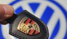 Das Porsche-Firmenlogo vor dem Logo des Volkswagen-Konzerns. Foto: dpa