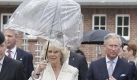 Englisches Wetter fr den kniglichen Besuch aus England. Den vereinzelten Regenschauern trotzte das Paar mit einem durchsichtigen Schirm.  Foto: dpa