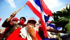 Regierungsgegner schwenken die thailändische Flagge auf einer Beerdigungsprozession in Bangkok. Bei den anhaltenden Protesten wurden bisher 21 Menschen getötet und mehr als 800 verletzt. Foto: ap