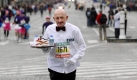 Ist dieser alte Herr, der den Pariser Marathon im Kellneroutfit läuft und seinen Laufschuh auf dem Tablett serviert, ein Kellner? Foto: dpa