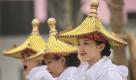 Chinese models wearing pagoda roofs wait for their street parade at the Shanghai World Expo Saturday May 8, 2010 in Shanghai, China. (AP Photo/Eugene Hoshiko) Foto: ap