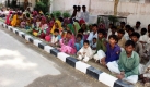 Pakistanische Bauern, die von der Polizei aus der Gefangenschaft gerettet wurden, sitzen in Hyderabad (Pakistan) auf einer Straße. Viele Menschen in finanzieller Not bekommen in Pakistan einen Kredit, sofern sie sich und ihre Arbeitskraft verkaufen. Foto: dpa