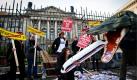 Eine Aktivistin von Campact (Demokratie in Aktion) schiebt vor dem Bundesrat in Berlin bei einer Protest-Aktion gegen das Bahnprojekt Stuttgart 21 einem als Krokodil verkleideten Aktivisten das Modell eines ICE-Zuges und unechte Geldscheine in den Rachen. Die Aktivisten demonstrierten vor dem Bundesrat gegen das Städtebauprojekt zur Neuordnung des Eisenbahnknotens Stuttgart. Foto: dapd