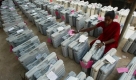 A worker sits with electronic voting machines before they are transported to the venue for the second phase of general elections in Bhubaneswar, India, Tuesday, April 21, 2009. India's national elections, which began Thursday will take place over five phases until May 13. (AP Photo/Biswaranjan Rout) Foto: ap