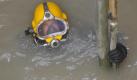 Industrietaucher Nico Spaar schwimmt in der Baustelle eines Abwasserkanals in Köln. Wenn Spaar mit seinem rund 22 Kilo schweren Taucheranzug unter Wasser geht, ist er nur noch mit einem schwarz-rot-gelben Kabel mit der Aussenwelt verbunden. Sehen kann er in der drei Meter tiefen braunen Brühe nahe dem Rhein nichts. Foto: ddp