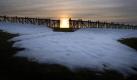 Die untergehende Sonne steht hinter einem Schneefangzaun im schwäbischen Eggenthal. Foto: Karl-Josef Hildenbrand Foto: dpa