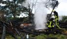 Mitarbeiter der Feuerwehr stehen in Brakel im Landkreis Höxter vor den Überresten einer ausgebrannten Scheune. Nach dem Löschen des Brandes hat die Polizei am Montagmorgen eine wahrscheinlich männliche Leiche entdeckt. Die Identität des Mannes ist noch ungeklärt.  Foto: dapd