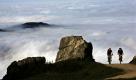 Zwei Mountainbiker fahren auf der Steinlingalm unterhalb der Kampenwand im Chiemgau vor dem Nebel im Tal der Sonne entgegen. In und an den Bergen herrscht in diesen Tagen sonniges warmes Herbstwetter, während sich im Flachland dichter Hochnebel hält.  Foto: dpa
