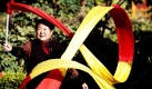 Eine Seniorin wirbelt in einem Park in Peking als Morgengymnastik ein buntes Band  in der Luft umher. Die Anzahl der sportlich aktiven Rentner in Peking steigt mehr und mehr. Foto: dpa