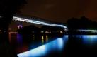 Ein heller Wurm windet sich über den Kanal in Oberhausen. Die Slinky springs to Fame-Brücke des Frankfurter Bildhauers T. Rehberg ist 406 Meter lang und mit 496 Metallspiralen versehen. In der Nacht wird das Kunstwerk beleuchtet. Foto: dpa