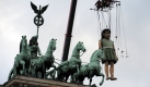 Tag der deutschen Einheit in Berlin:Die siebeneinhalb Meter große Kleine Riesin wird über das Brandenburger Tor in Berlin gehoben. Rund um den Tag der Deutschen Einheit gastiert die Open-air-Theateraufführung der französischen Compagnie Royal de Luxe Die Riesen kommen in der Bundeshauptstadt. Die Künstler mit den gigantischen Figuren erzählen eine Geschichte von Trennung und Wiederfinden. Sie wollen damit an den Mauerfall vor 20 Jahren erinnern. Foto: dpa