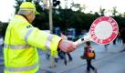 Ein freiwilliger Helfer des Schulwegdienstes hilft in der Dachauerstraße in München Schülern und auch Erwachsenen die Straße sicher zu überqueren. Für 1,81 Millionen Schüler in Bayern hat vor einer Woche wieder der Ernst des Lebens begonnen. Rund 110.000 Kinder wurden neu eingeschult. Foto: dpa