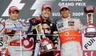 Die drei Erstplatzierten stehen nach dem Rennen auf dem Podium. Jarno Trulli (l.) wurde Zweiter, Hamilton Dritter. Die beiden nehmen Sieger Vettel in die Mitte. Foto: dpa