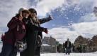 Zwei Touristinnen aus Taiwan werfen auf der Aussichtsplattform der Zugspitze bei Garmisch-Partenkirchen Schnee für ein Erinnerungsfoto in die Luft.
 Foto: dapd