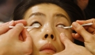 Diesem Model wird Make-up bei den Frühjahrsmodeschauen in Mailand aufgelegt. Foto: ap