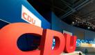 Ein übergroßes Logo der CDU bildet die Kulisse für den Bundesparteitag in Leipzig. Foto: Peter Endig Foto: dpa