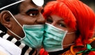 Ein Karnevalist mit Obama-Maske wird in Kölnn geküsst, wo sie den Beginn der Karnevalssession 2010 feiern. Trotz Schweinegrippegefahr lautet das Motto in dieser Session in Köln In Kölle jebützt - In Köln geküsst. Foto: dpa