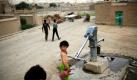Ein kleines Mädchen befüllt im afghanischen Kabul Kannen mit Wasser von einem Brunnen. Foto: ap