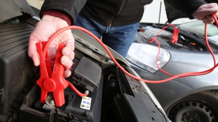 Erster Schritt zur Starthilfe: Das rote Kabel wird an die Pluspole beider Batterien geklemmt.